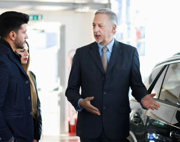 男性がお客様に車の説明する様子